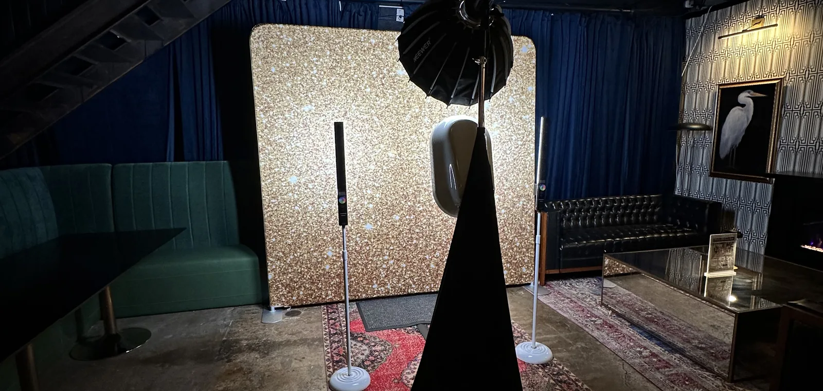 A gold sequin backdrop and the photo booth set up in a dark lounge venue
