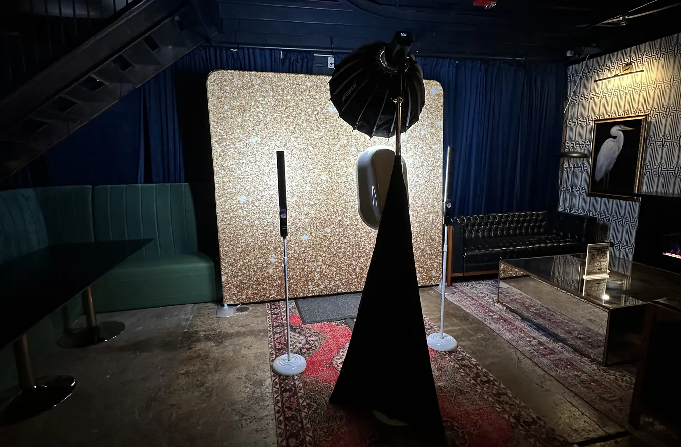 The photo booth and a gold sequin backdrop standing ready in an empty venue