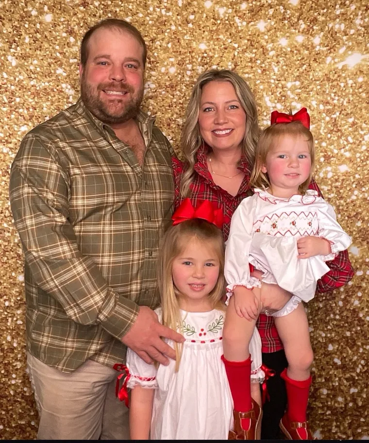 A family of four photographed at the gold sequin backdrop during a church Christmas night