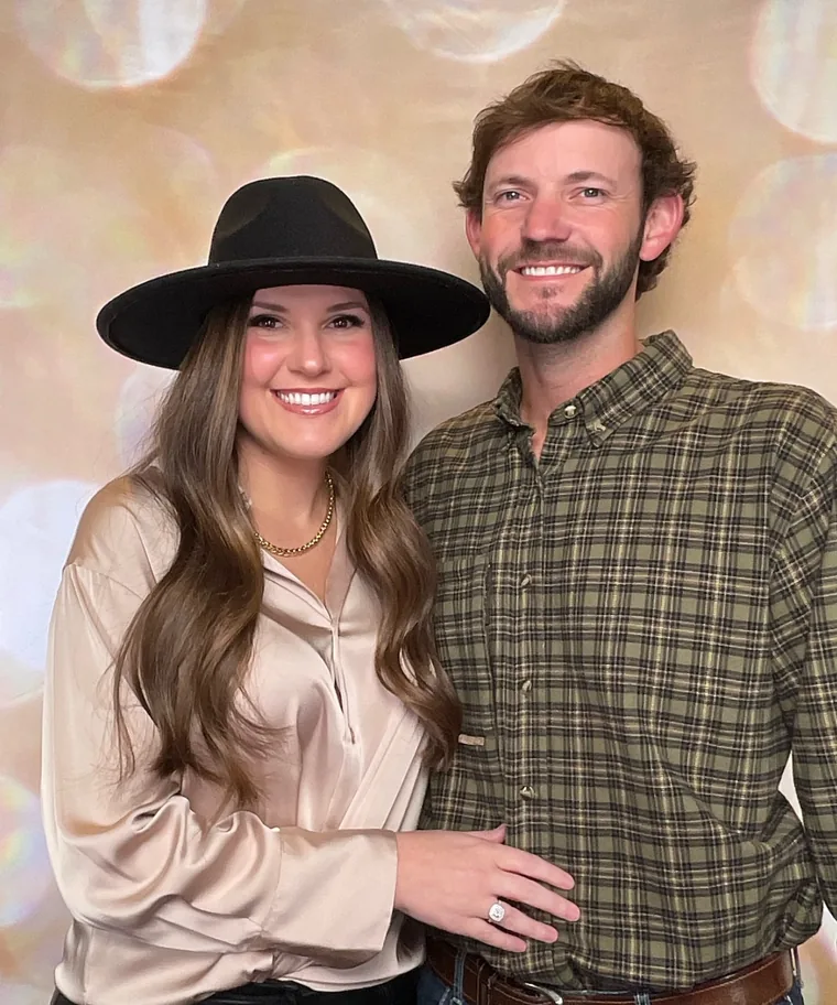 Two guests at a company Christmas party posing in front of a warm bokeh backdrop