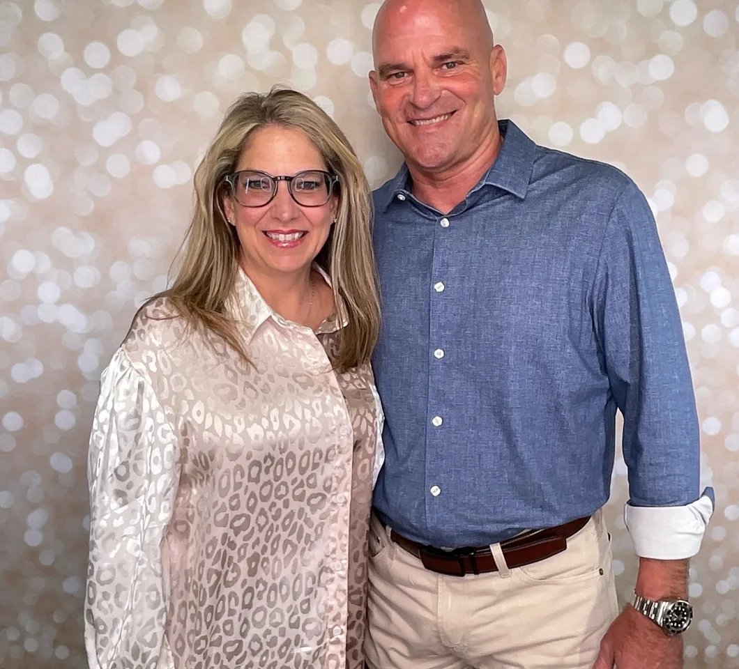 A couple photographed in the booth in front of a soft gold bokeh backdrop